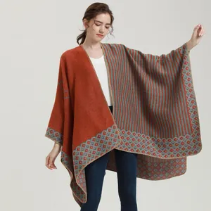 Detail of knit shawl wrap with brick red and grey green stripes and diamond patterns