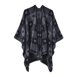 Detailansicht eines Strickponchos mit grauem Schachbrettmuster und schwarzen Herzmotiven
