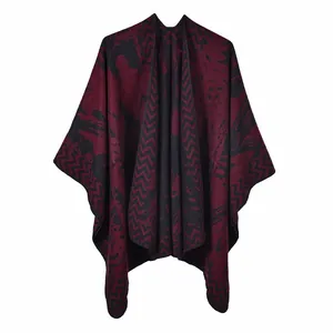 Macro shot of burgundy and black knitted poncho showing wavy texture and ink pattern