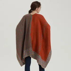 Detail of knitted shawl with rust red and grey blue stripes and diamond patterns