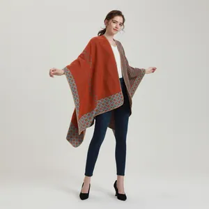 Detailed close-up of orange and grey geometric knit pattern on the shawl edge