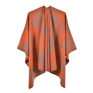 Détail de la texture jacquard florale orange et grise sur cette cape de châle vintage