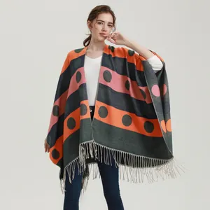 Women's colorful knit poncho with polka dots, stripes, and long tassel hemline