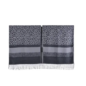 Detailed close-up of grey leopard print shawl featuring fringed edges and soft knit texture