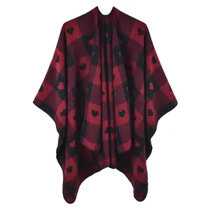 Detail des rot-schwarzen Buffalo-Plaid-Ponchos mit Herzmustern und weichem Strickgewebe