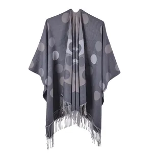 Detail of grey polka dot cashmere-like shawl featuring soft texture and long fringe