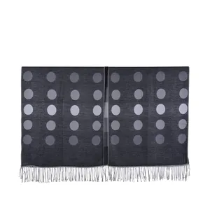 Detail view of dark grey cashmere-like shawl with light purple polka dots and tassels