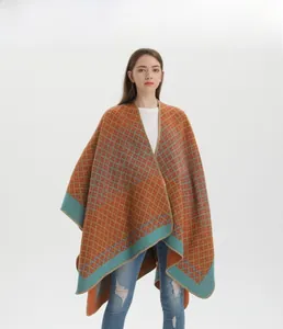 Detail of soft knit shawl featuring geometric orange and teal diamond pattern with hem finish