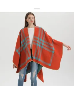 Close-up of orange plaid shawl cape with soft knit texture and fringe stitching details