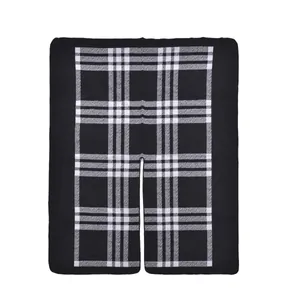 Detail view of thick black and white plaid poncho with soft knit texture and open front