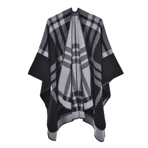 Close-up of black and grey plaid poncho with fine overlock stitching and knit texture