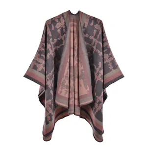 Detail of knit shawl featuring abstract geometric patterns in grey and pink tones