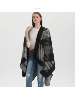 Détail du motif à carreaux géométriques noir et blanc sur cette cape châle en maille