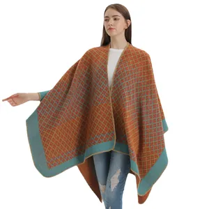 Women's knit shawl poncho with orange and blue geometric patterns in an oversized fit