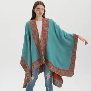 Detailed knit texture of turquoise ethnic shawl with orange geometric patterns and fringe