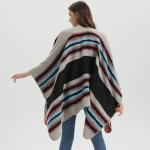Detail of soft knitted poncho featuring colorful wave stripes and delicate edge stitching