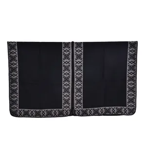 Detail of black shawl showing ethnic geometric jacquard border and thick knit texture