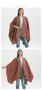 Detail of vibrant floral knit shawl with orange and blue swirl patterns and gold trim