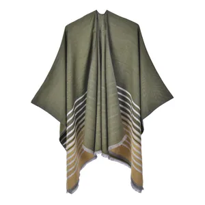Détail du châle en tricot vert olive avec rayures orange et bords à franges