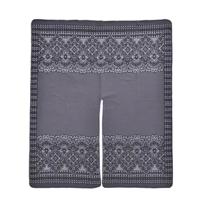 Close-up of grey knit poncho showing vintage floral jacquard and fine ribbed hem