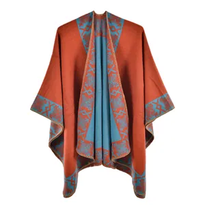 Detail of burnt orange knit poncho with light blue bohemian geometric patterns