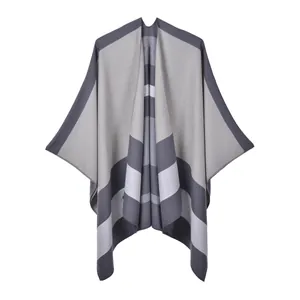 Detail of grey striped knit poncho showing the soft texture and hem stitching quality