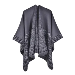 Close-up of dark grey knit poncho with exquisite floral lace-style hem texture