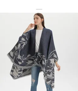 Detailed view of dark blue and grey floral patterns and fine fringe tassels on a pashmina shawl