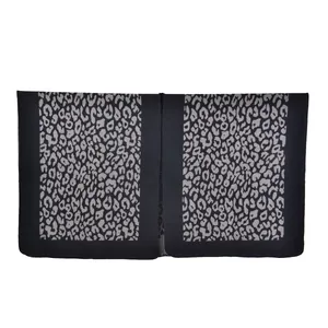 Close-up detail of leopard print shawl with thick knit texture and black border finish