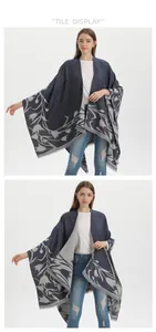 Detailed view of reversible dark blue knit shawl with grey floral patterns and fringe edge
