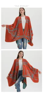 Detail view of the equestrian pattern and thick knit texture on the orange warm poncho shawl