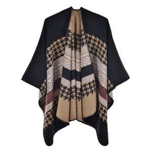 Détail d'un poncho en maille avec motifs pied-de-poule et rayures en kaki et noir