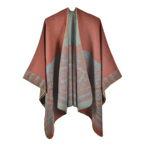 Detail of vintage red knit poncho with blue floral jacquard pattern and overlock edge