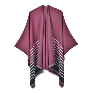 Détail de la texture du châle en tricot bordeaux avec ourlet à rayures noires et blanches