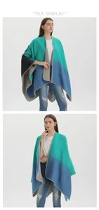 Detail of color-block knitted shawl showing the teal and grey fabric texture and drape