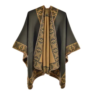 Detail of green ethnic poncho with thick cashmere-like texture and geometric knit patterns