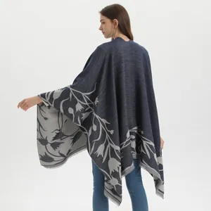Detail of navy and gray cashmere-like knit shawl showing intricate leaf patterns and tassels