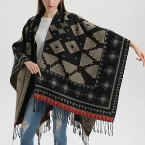 Détail d'un châle bohème en maille géométrique avec franges noires et texture épaisse