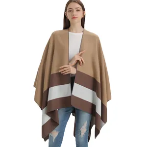 Women's camel stripe knit poncho cape styled with casual denim jeans on white background