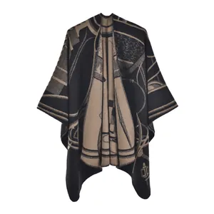 Detailed view of thick knit poncho showing black and brown jacquard patterns and texture
