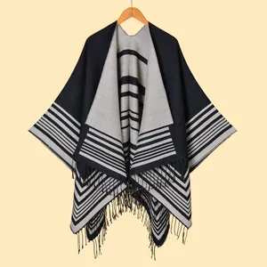 Detailed close-up of striped knit shawl featuring black tassels and geometric fringe trim