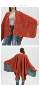 Detail view of orange knit shawl with teal star patterns and fine stitched edges