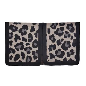 Close-up of leopard print shawl with thick knit texture and black reinforced edges