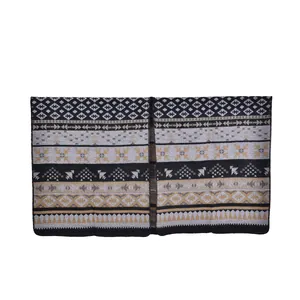 Detailed close-up of bohemian knit shawl featuring geometric patterns and fringe