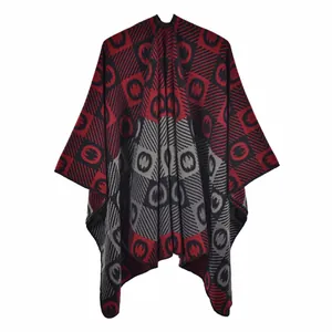 Detail of red and black geometric pattern on soft knit poncho with tassel textures