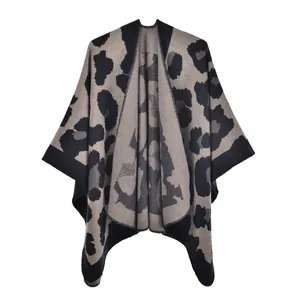 Detailed close-up showing the fine grey leopard print texture of a knit poncho wrap