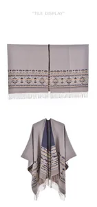 Detail showing Bohemian geometric knit patterns and tassel fringe on a gray shawl