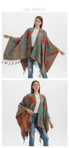 Detail of knitted plaid poncho with fringe hem in blue and orange color block