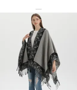 Detail of floral knit poncho featuring soft cashmere-like fabric and decorative tassels