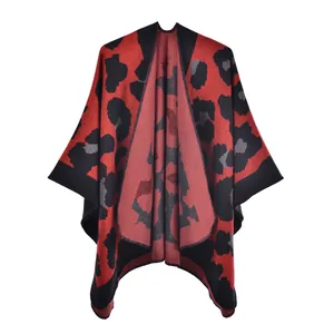 Detailed view of red leopard print knit shawl with thick fabric and black hemmed edges